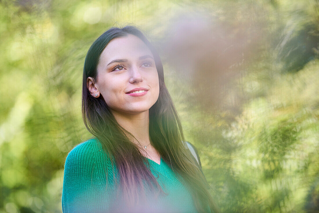 Thoughtful young woman standing in public park