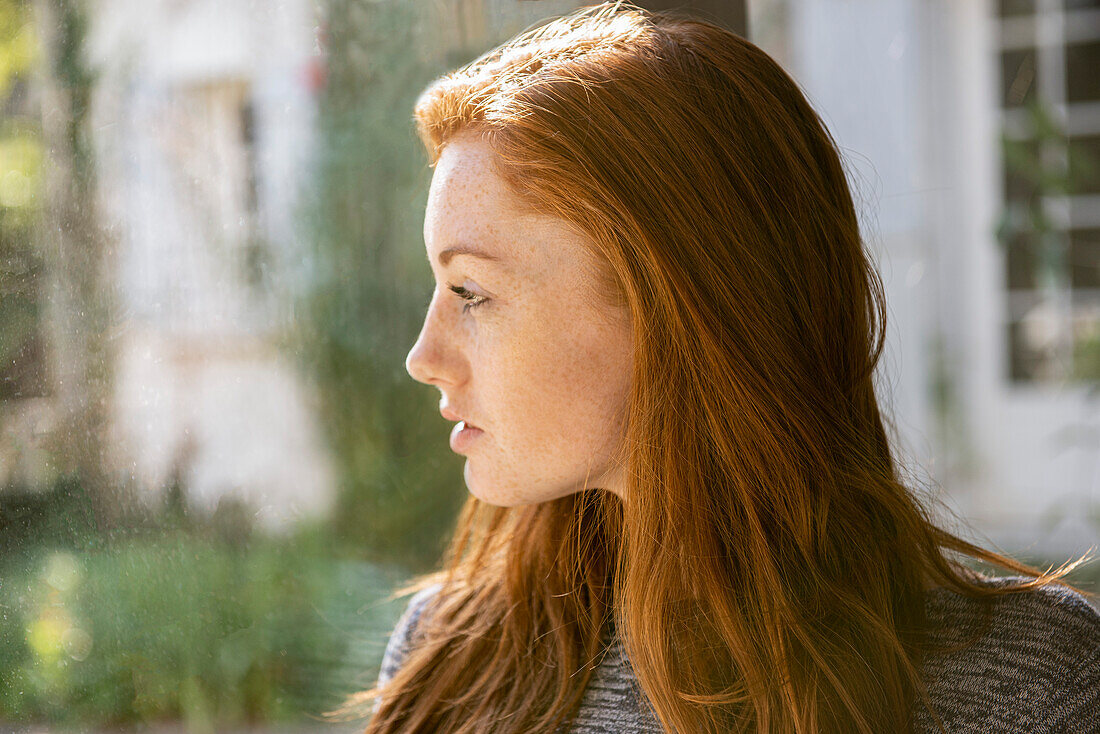 Serious young woman looking away in public park