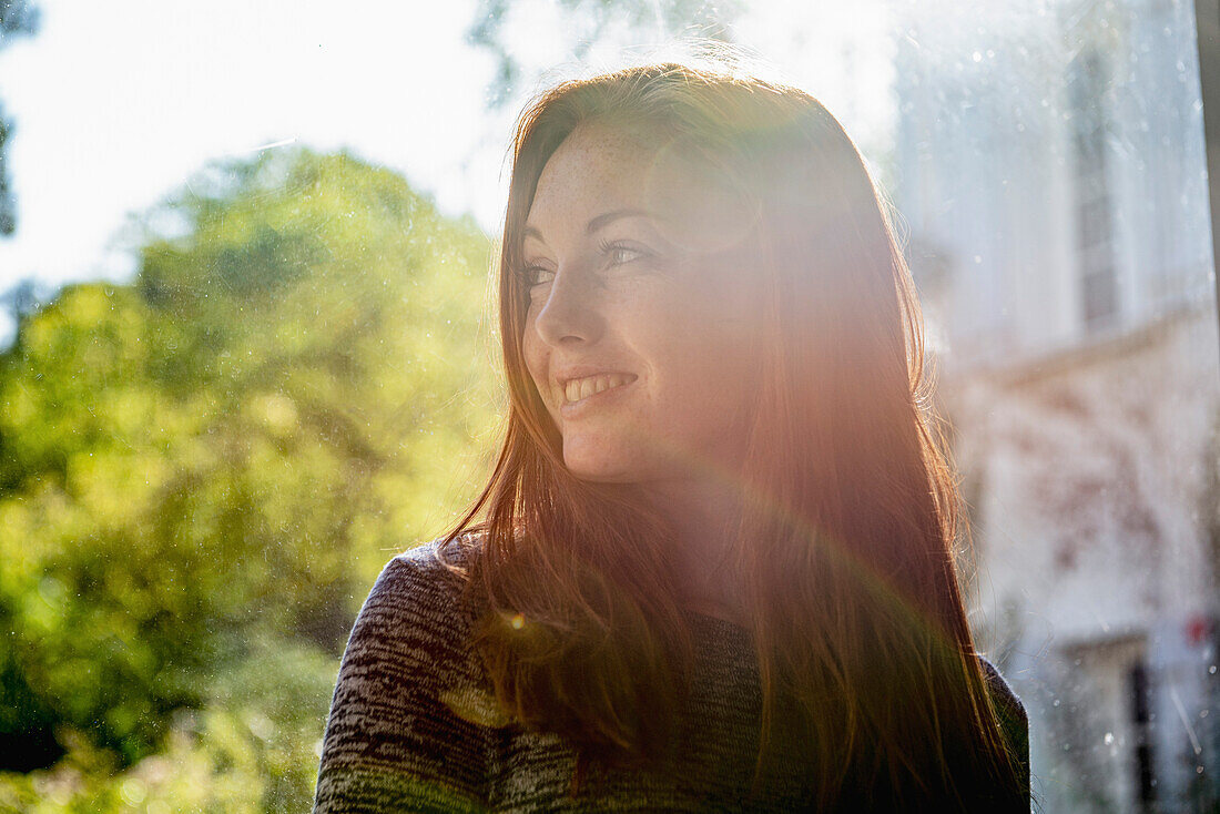 Smiling young woman looking away in public park