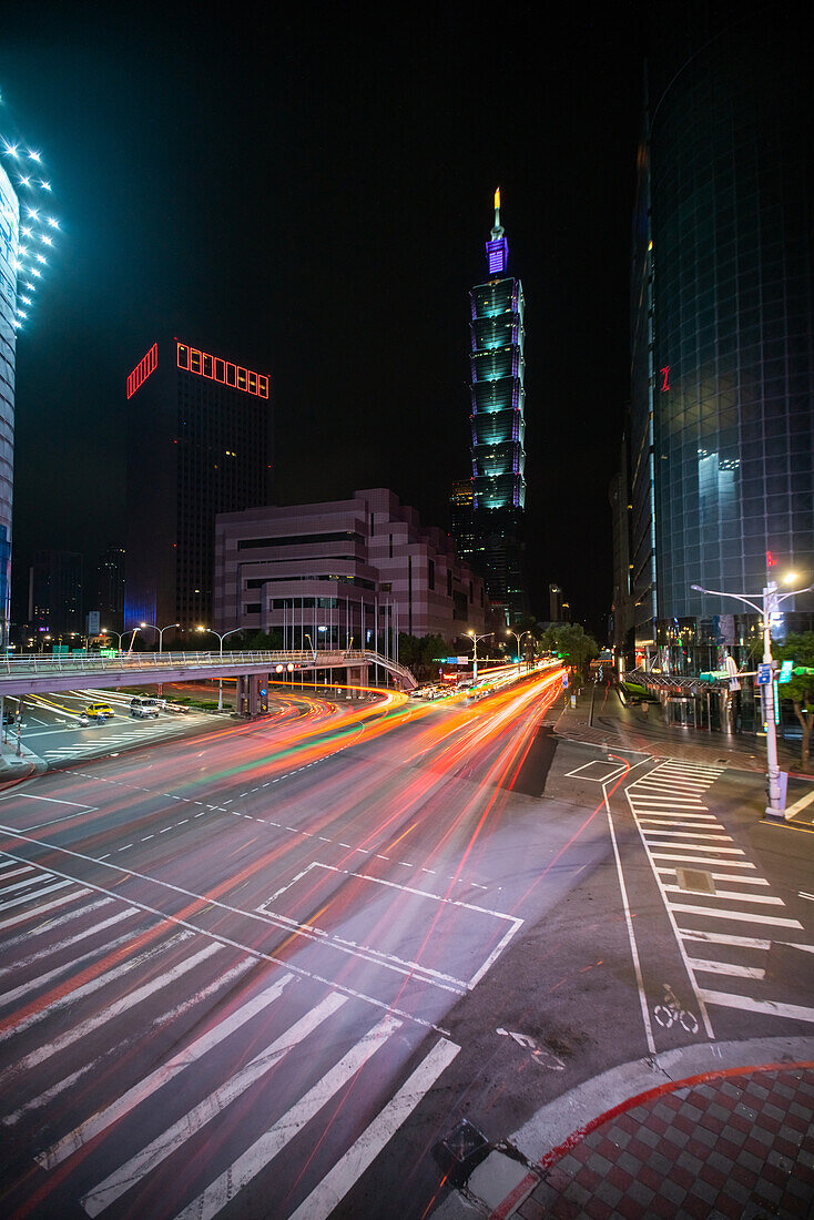 Verkehr auf einer Straße mit dem Gebäude Taipei 101 im Hintergrund, Taiwan