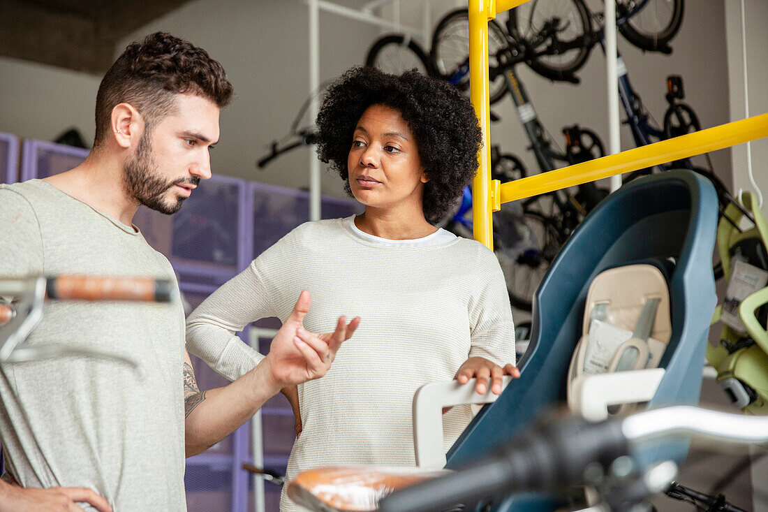 Bicycle store owner talking with African American female customer