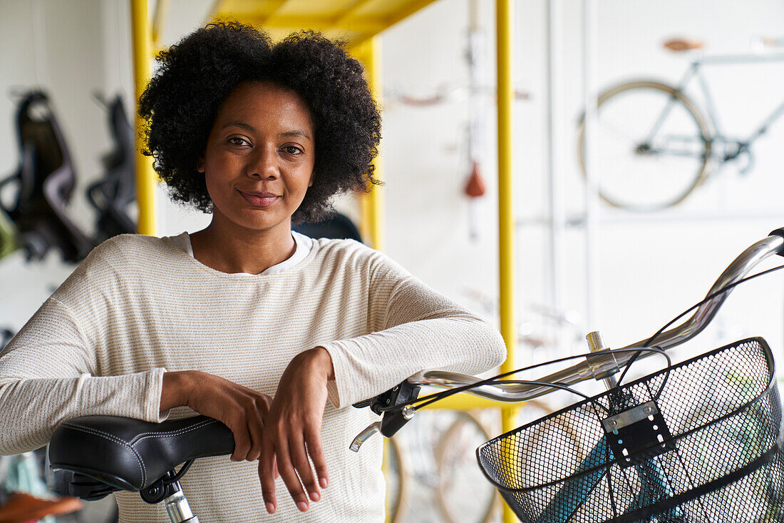 Porträt einer afroamerikanischen Geschäftsinhaberin, die in ihrem Fahrradladen steht