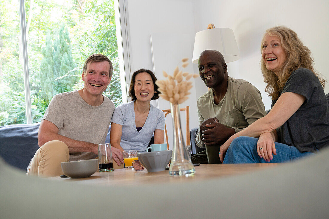 Lustige Gruppe von Freunden mittleren Alters, die sich zu Hause amüsieren