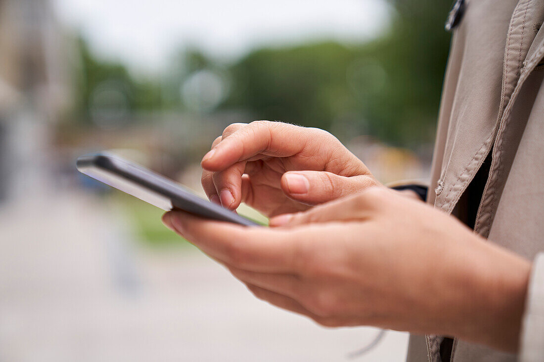 close-up shot of woman's hands tapping on a mobile phone screen
