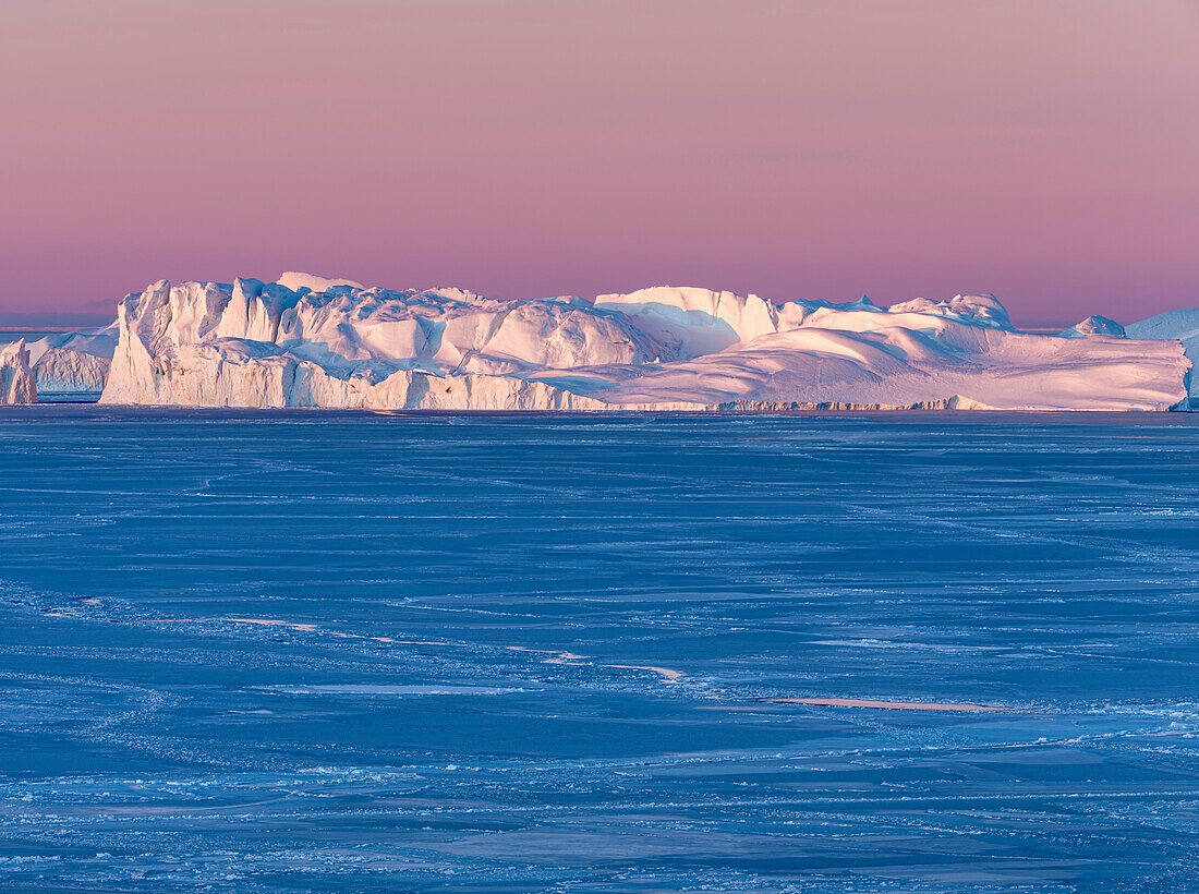 Sunrise during winter at the Ilulissat Fjord, located in the Disko Bay in West Greenland, the Fjord is part of the UNESCO World Heritage Site. Greenland, Denmark.