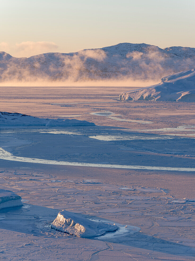 Sonnenaufgang im Winter am Ilulissat Fjord in der Diskobucht in Westgrönland. Der Fjord ist Teil des UNESCO-Welterbes. Grönland, Dänemark.