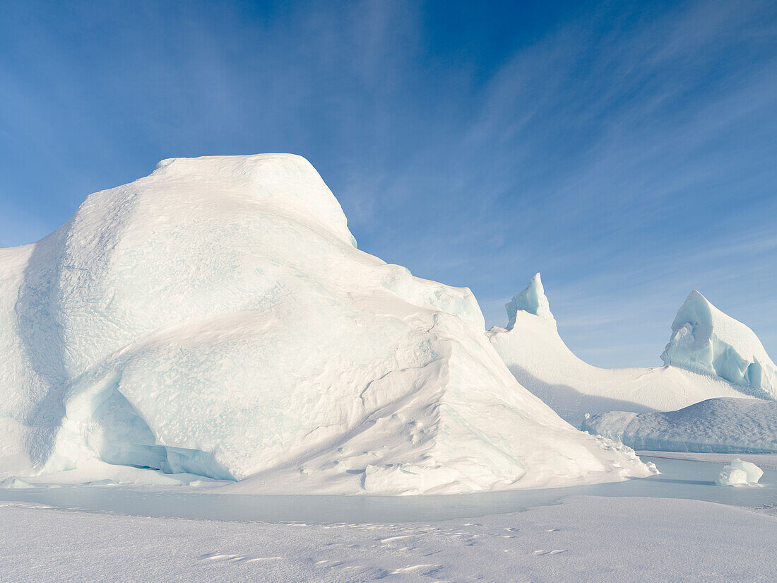 Iceberg frozen into the sea ice of the Melville Bay, near Kullorsuaq in the far north of West Greenland.