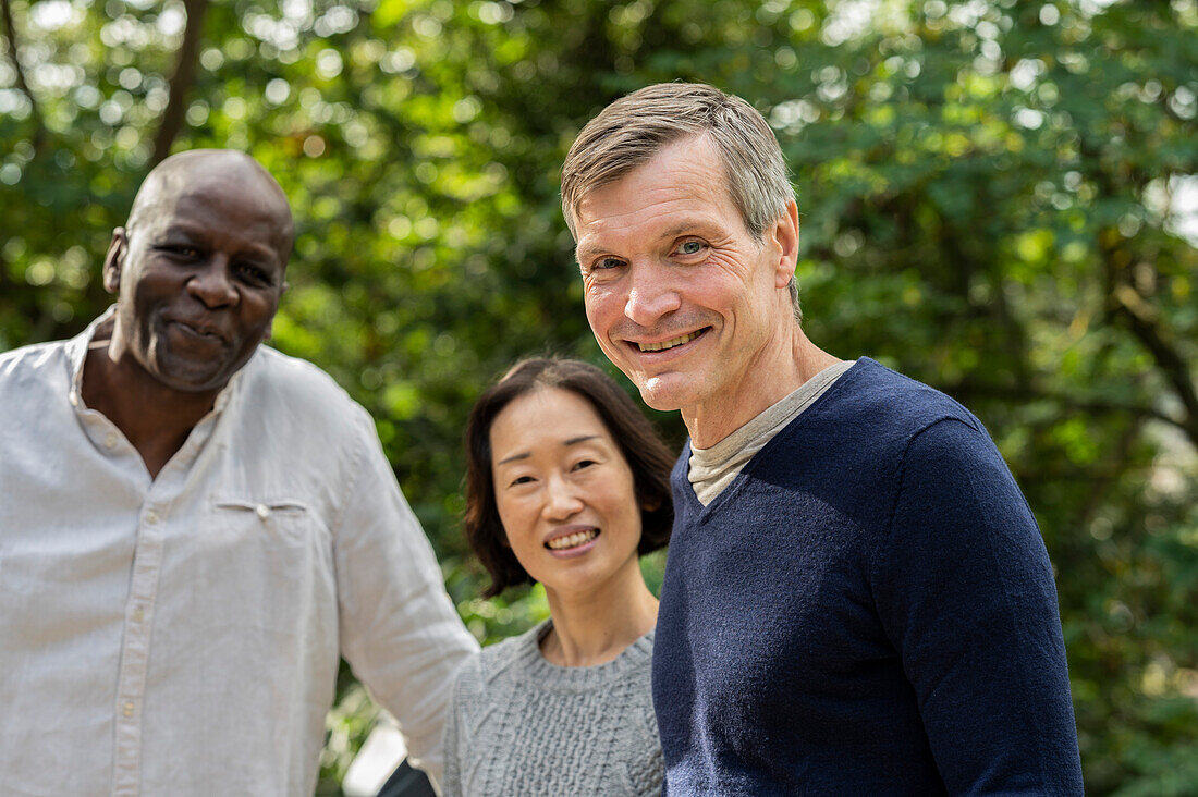 Portrait of middle age diverse group of friends gathered at public park