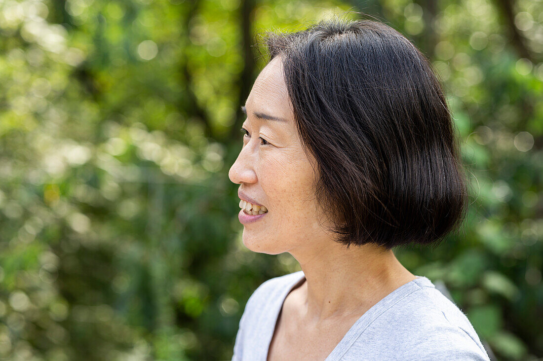 Seitenansicht einer älteren asiatisch-amerikanischen Frau, die im Freien steht