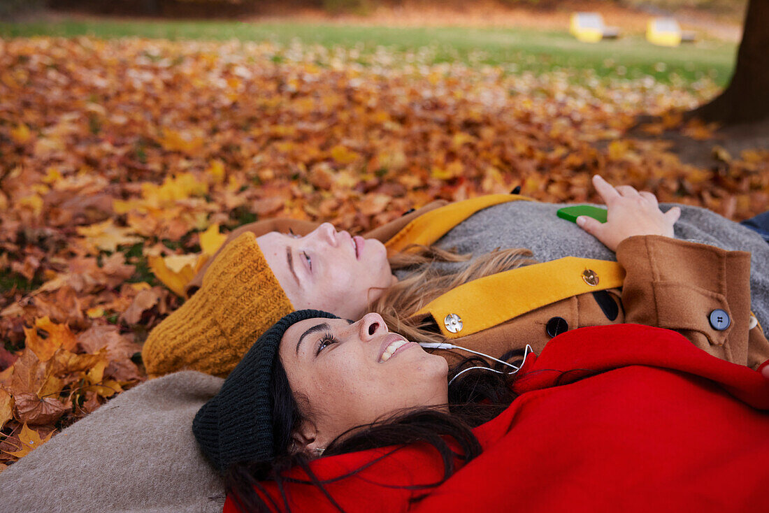 Friends lying on ground in autumn scenery