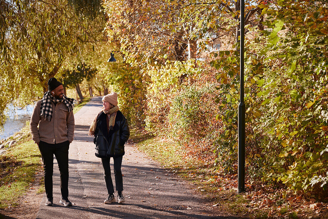 Mann und Frau spazieren im herbstlichen Park