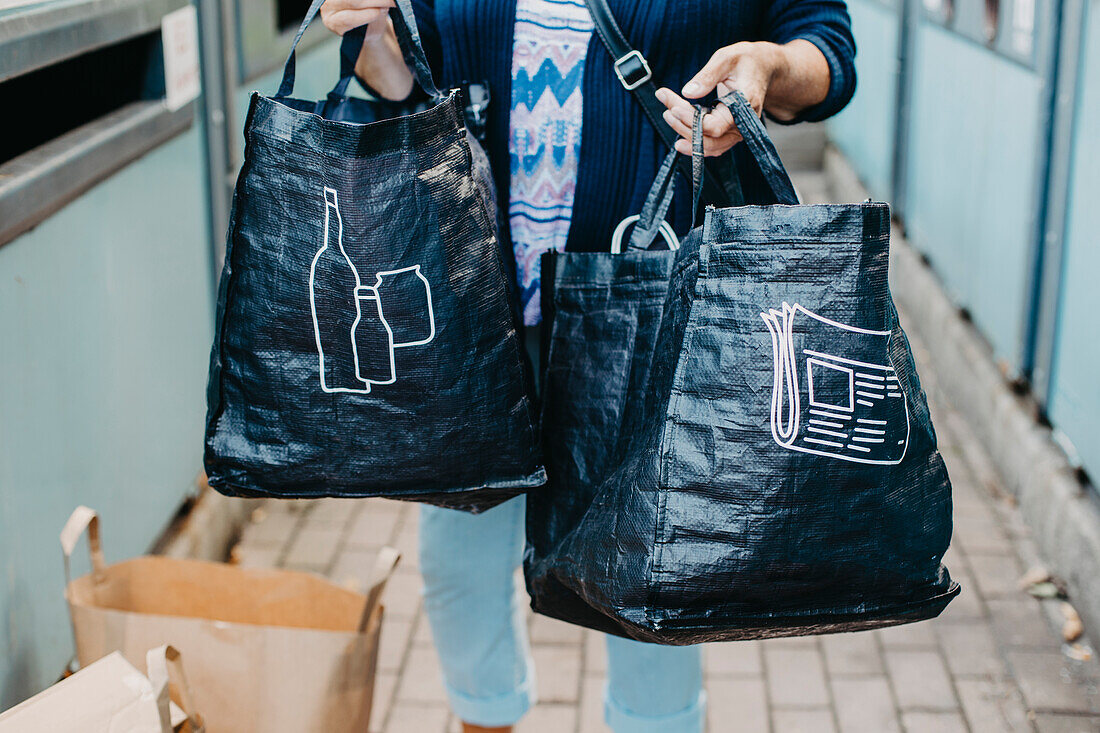 Woman holding bags with recycling