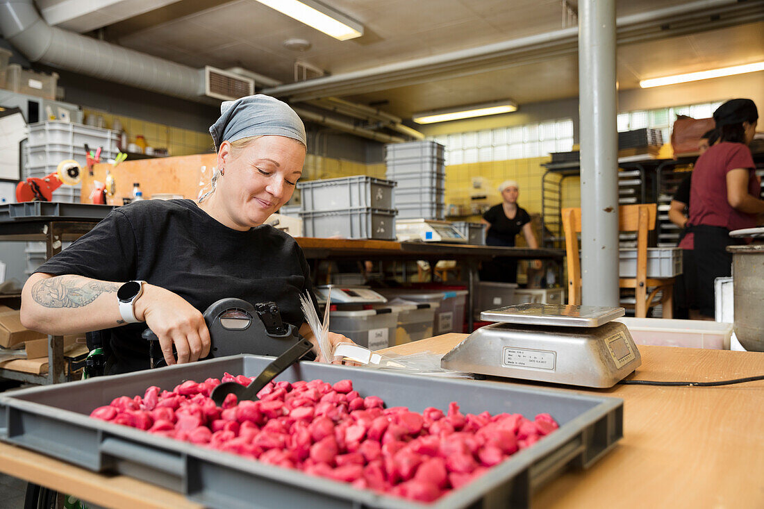 Behinderte Frau arbeitet in einer Lebensmittelfabrik