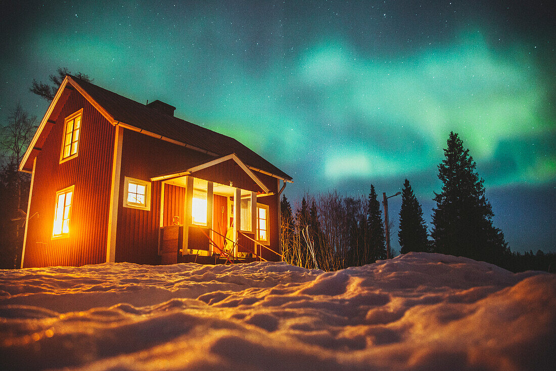 Aurora borealis over wooden house