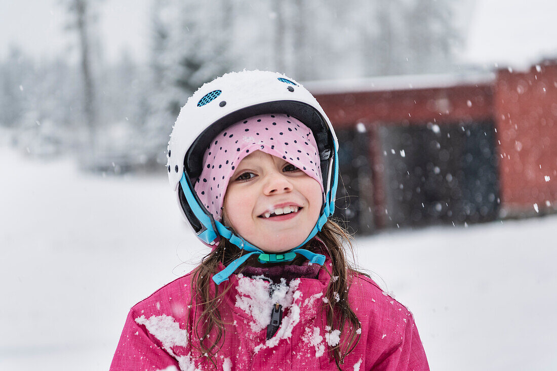Portrait of smiling girl wearing helmet in winter