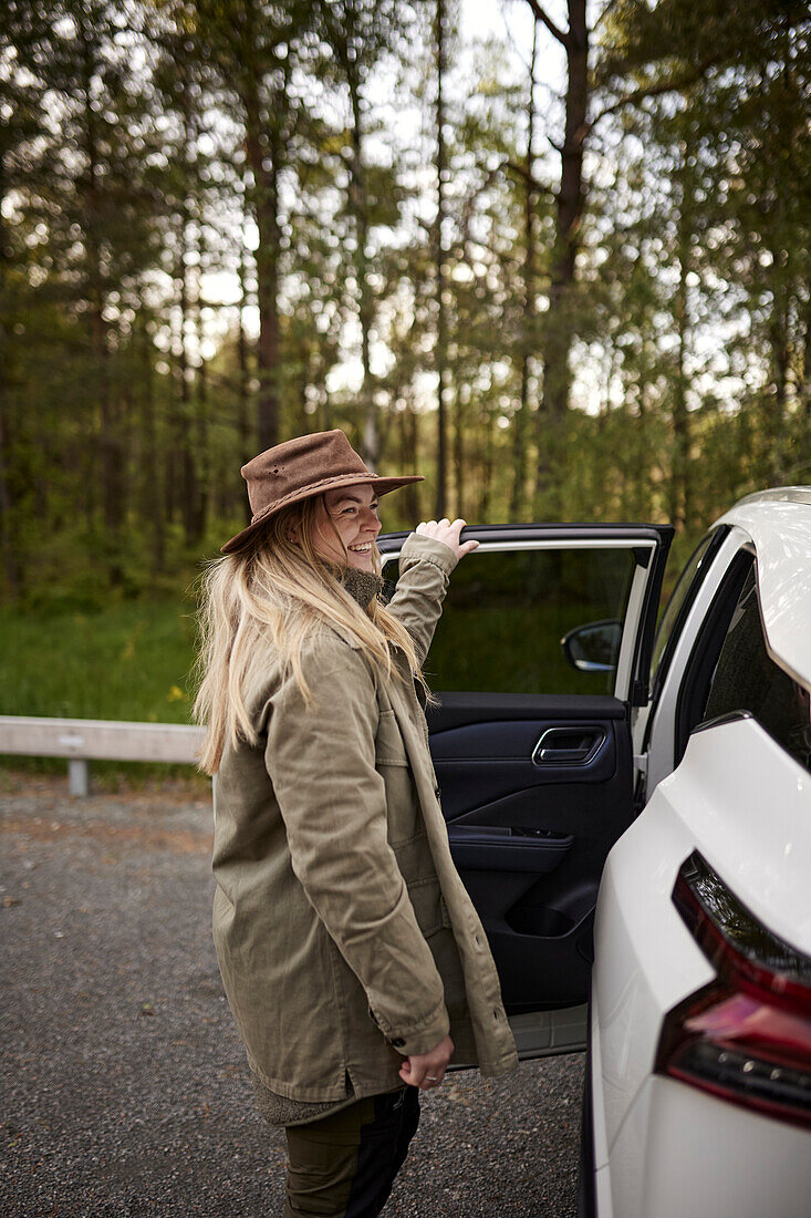 Smiling woman standing near car