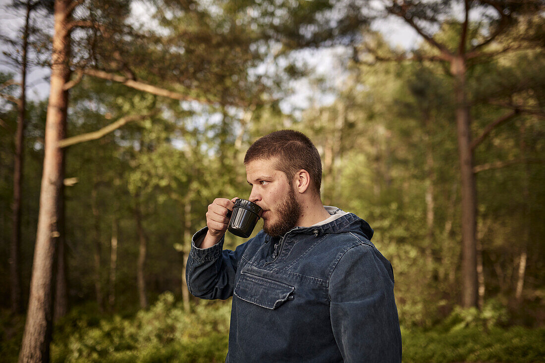 Mann trinkt Kaffee im Wald