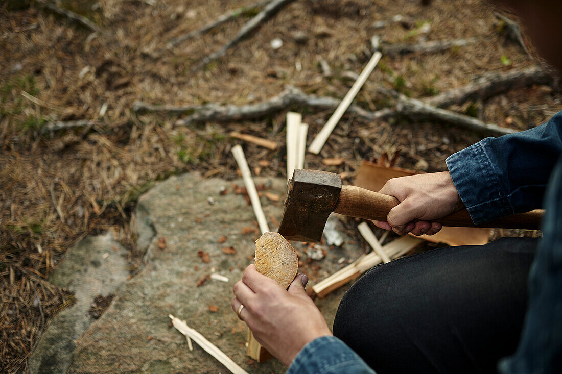 Hände mit Axt beim Holzhacken