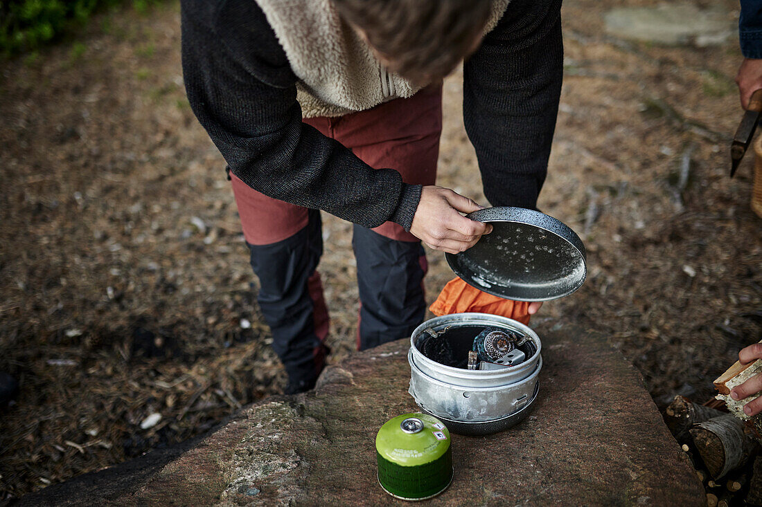 Person bereitet Campingkocher vor