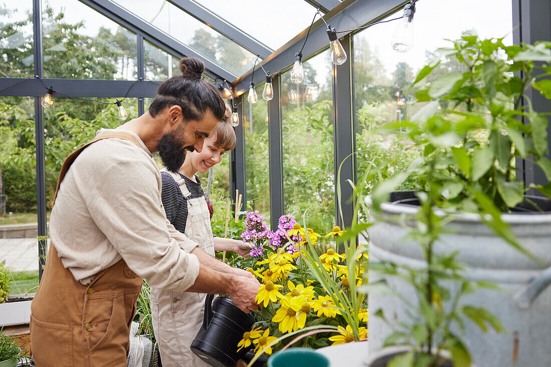 Pärchen bei der Gartenarbeit im Gewächshaus