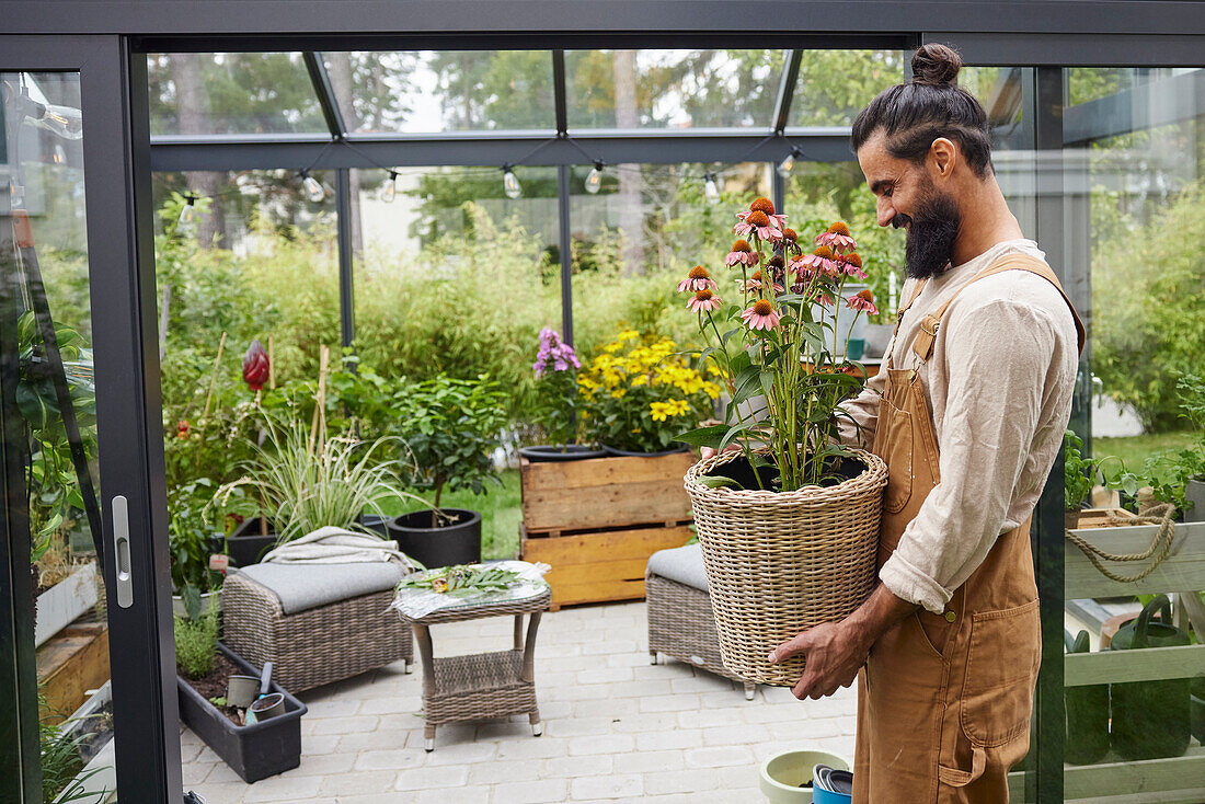 Lächelnder Mann hält Topfblumen