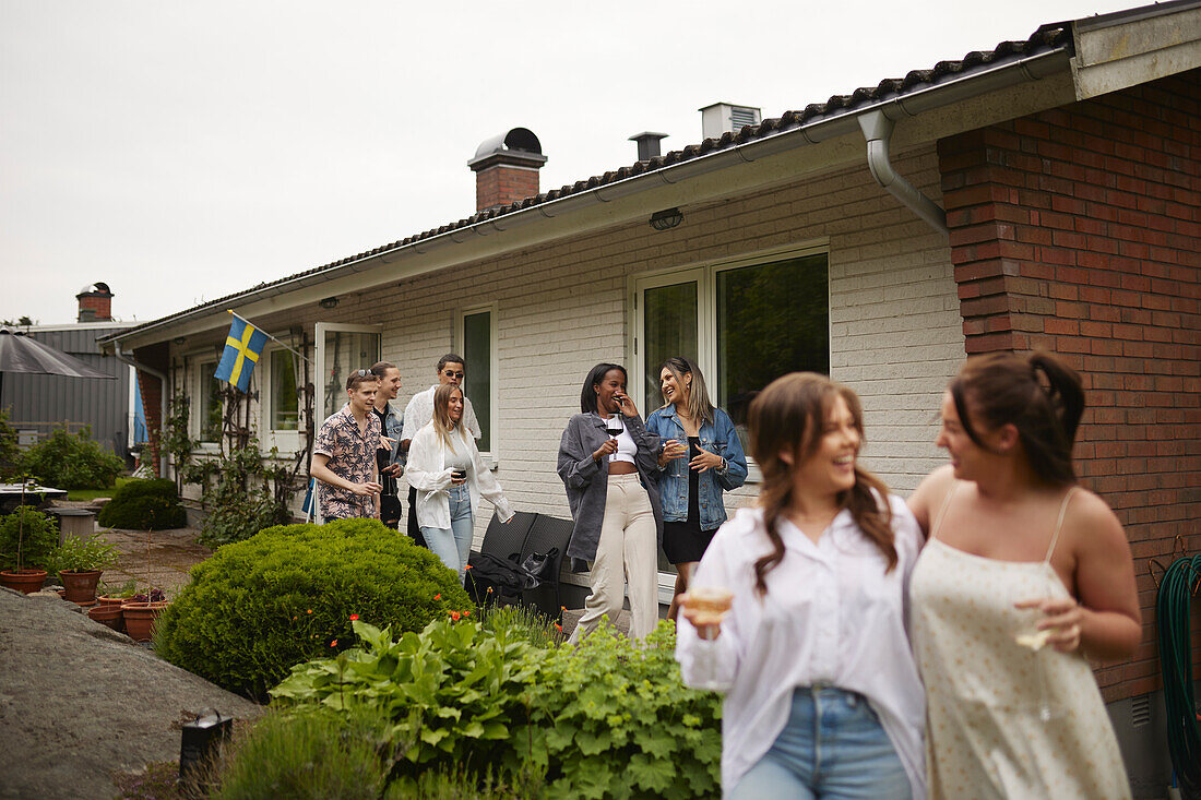 Happy friends in front of house