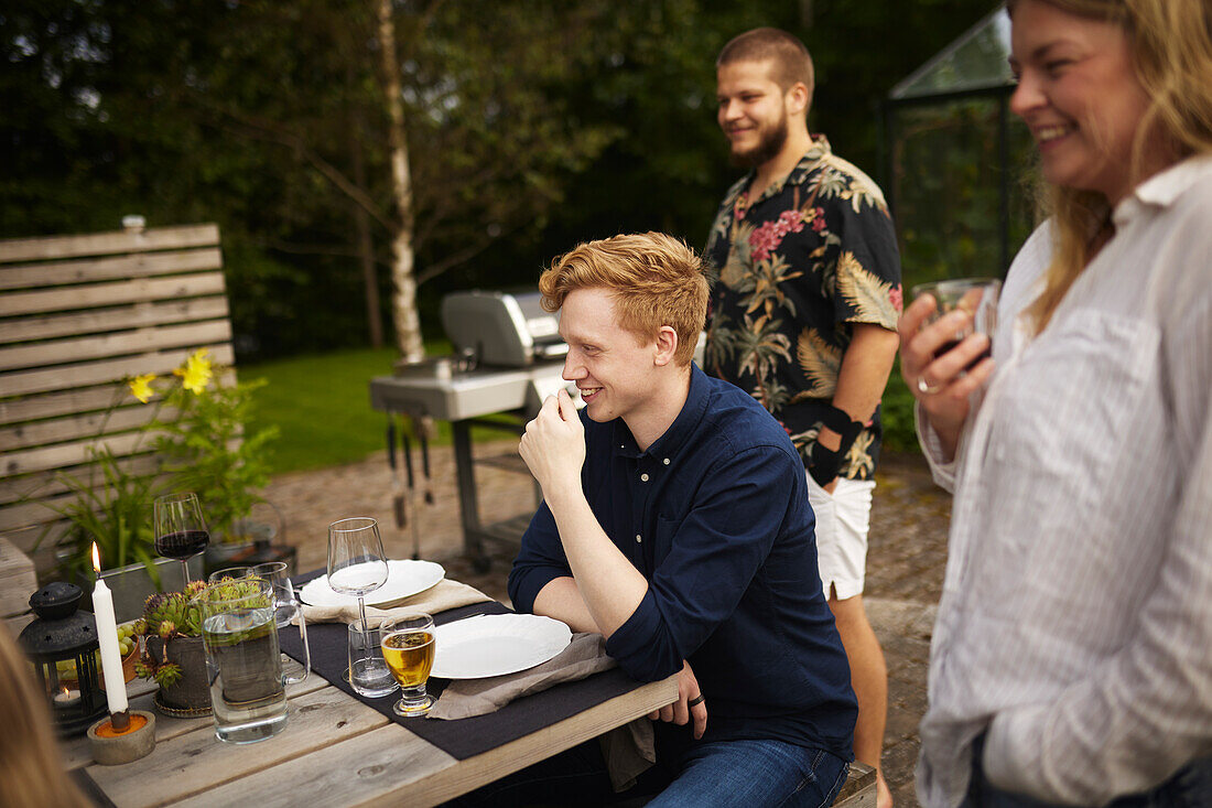 Glückliche Freunde beim Essen im Garten