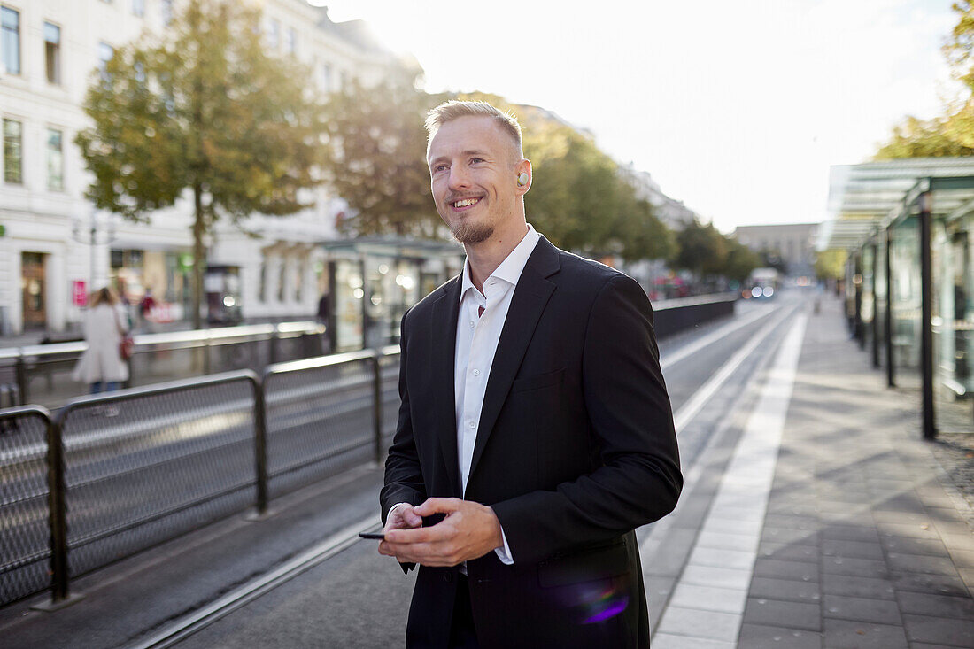 Businessman waiting at tram stop