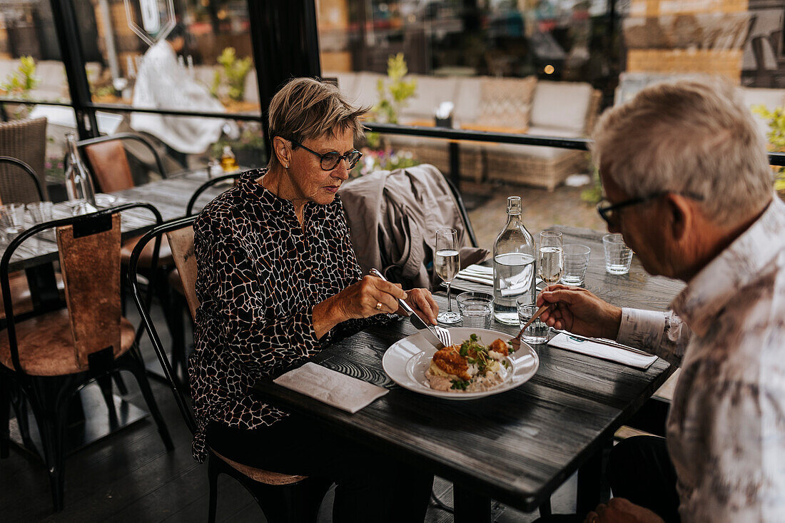 Senior couple sharing food in restaurant