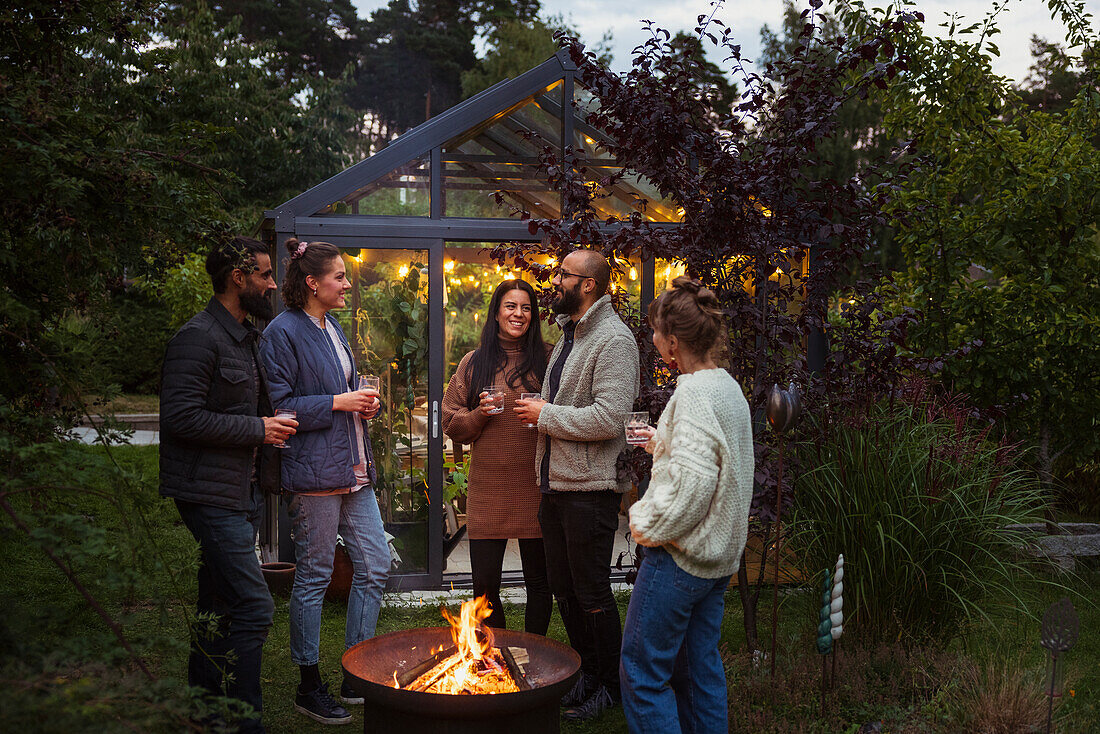 Glückliche Freunde unterhalten sich im Garten