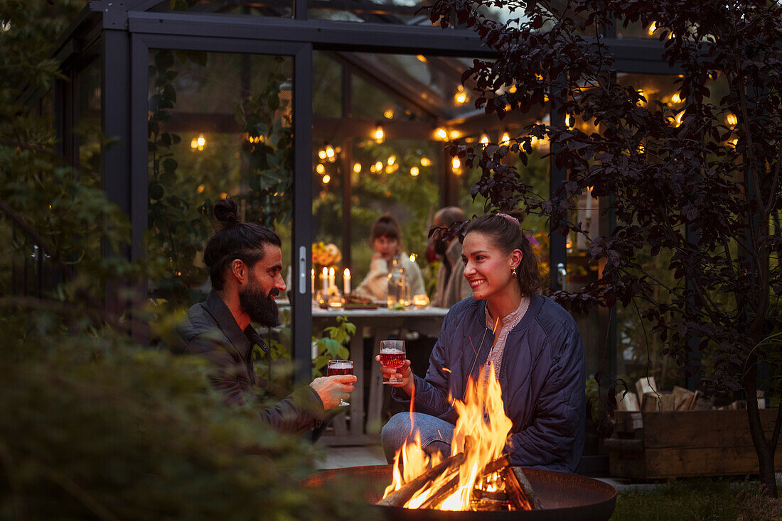 Friends sitting at fire in garden