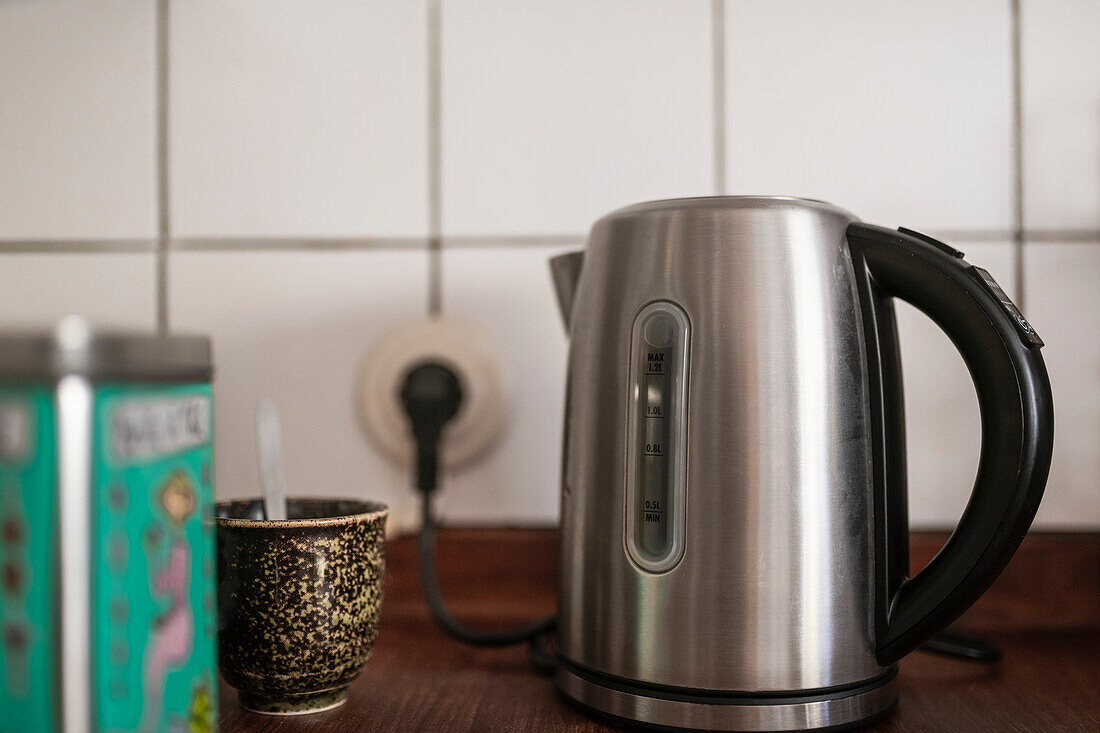 Elektrischer Wasserkocher und Tasse mit Löffel