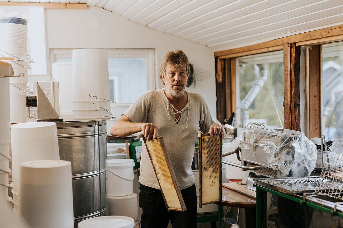 Mann hält Bienenstockrahmen