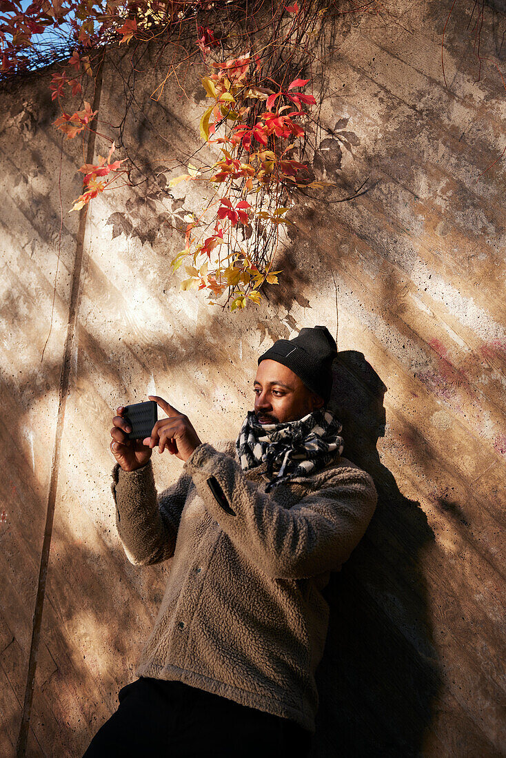 Mann fotografiert mit Mobiltelefon