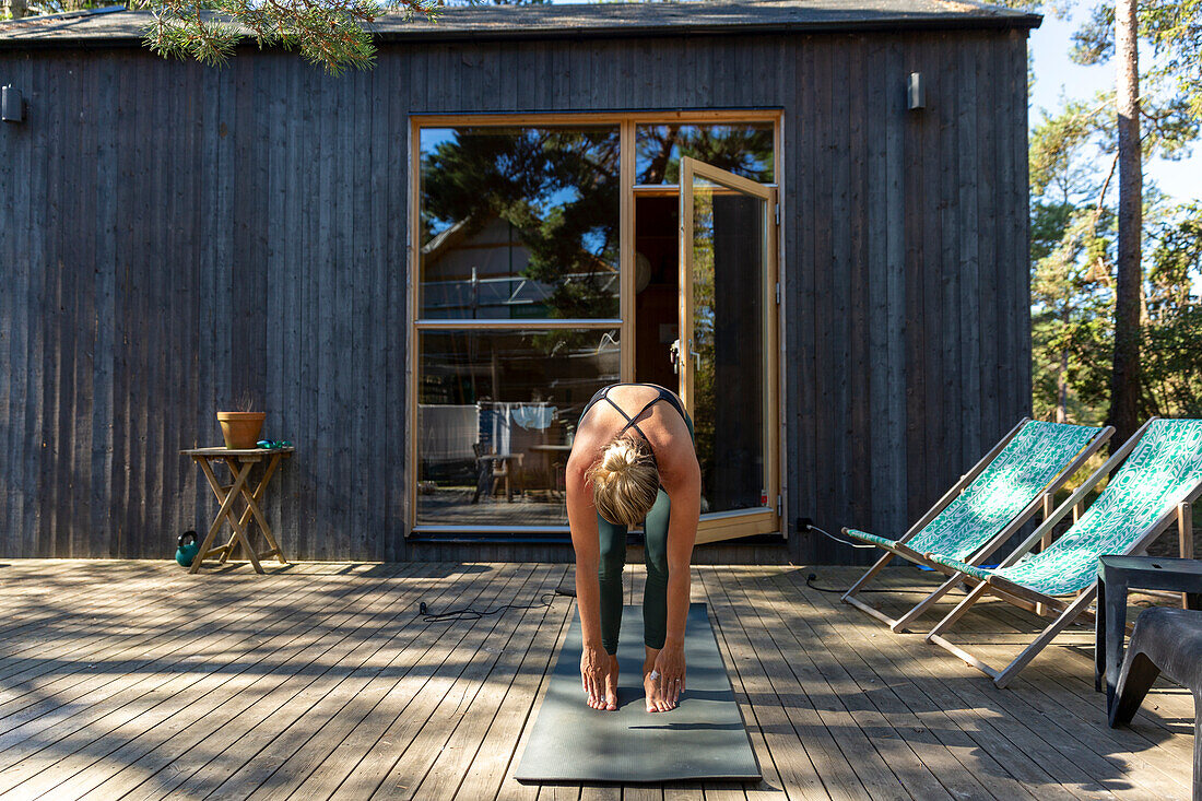 Woman practicing yoga on patio