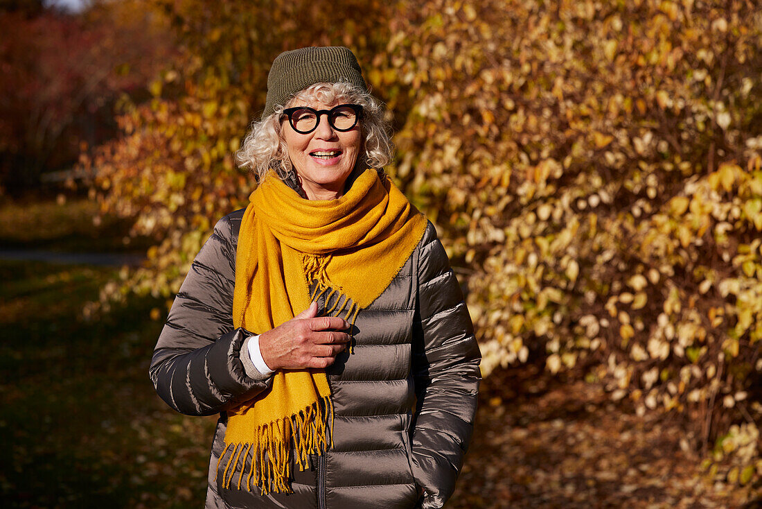 Porträt einer älteren Frau in einer Herbstlandschaft