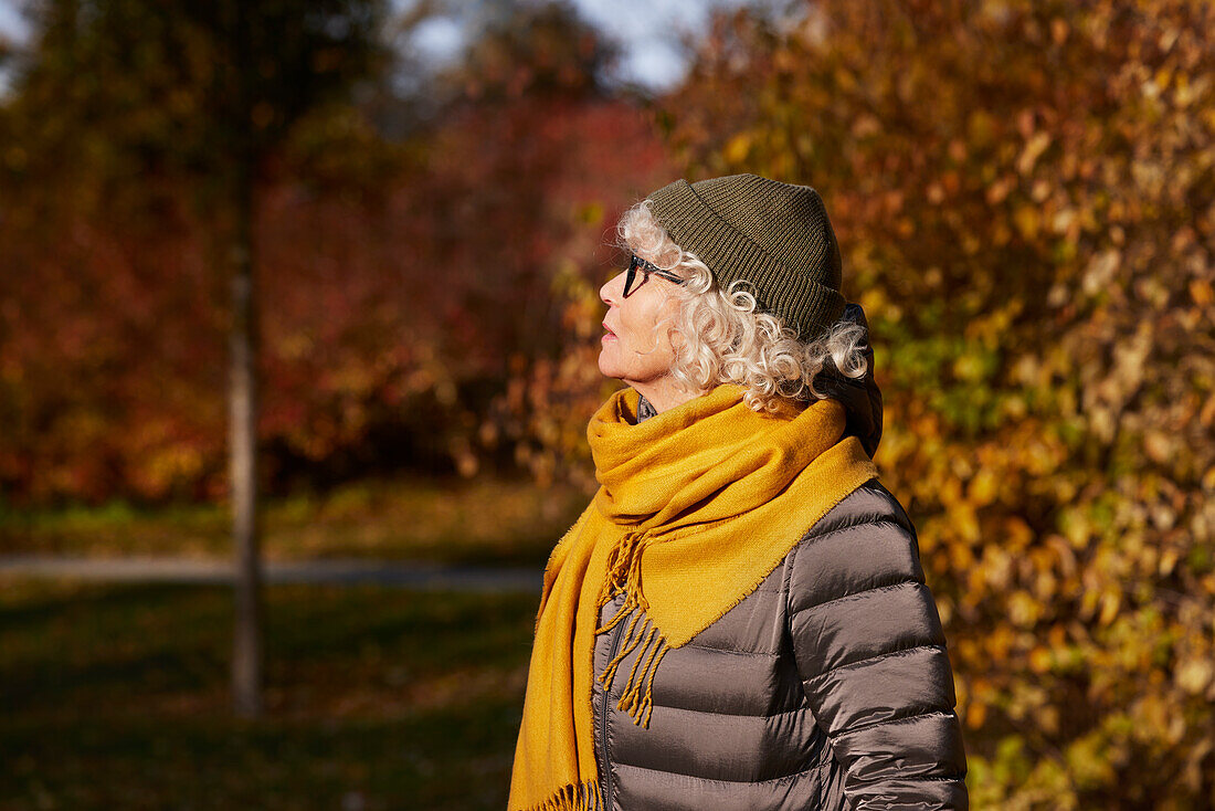 Porträt einer älteren Frau in einer Herbstlandschaft