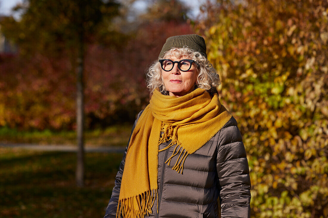 Porträt einer älteren Frau in einer Herbstlandschaft