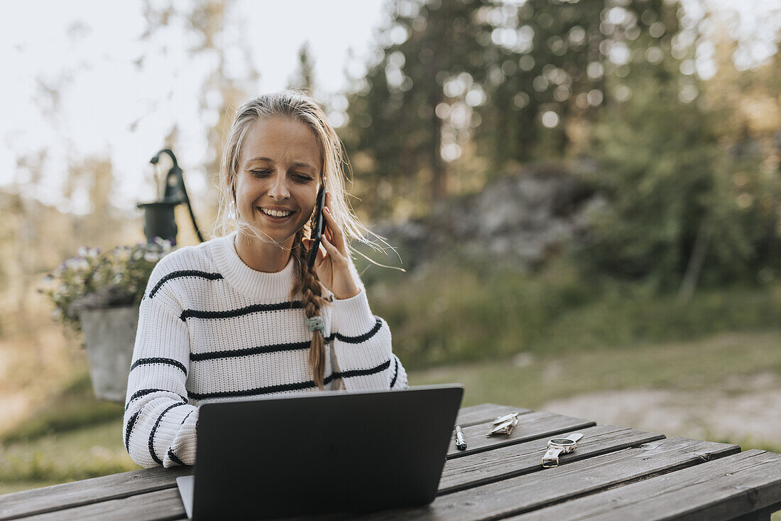 Junge Frau macht Notizen über ein Mobiltelefon