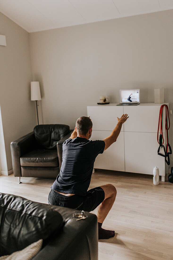 Man doing squats at home