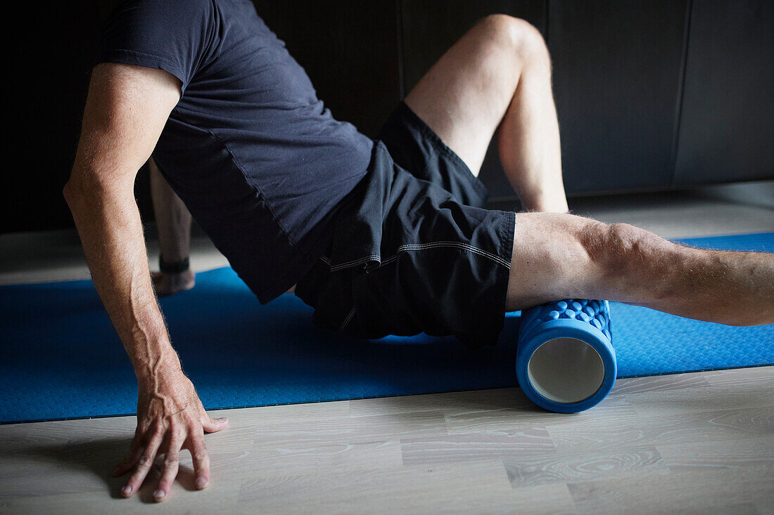 Man stretching and warming up using foam roller