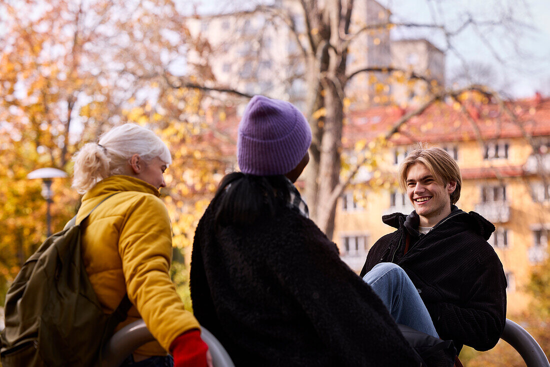 Three friends in park in autumn scenery