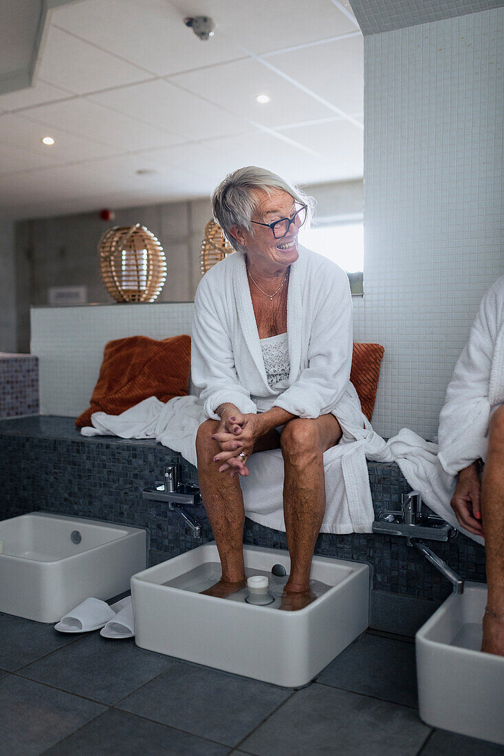 Senior woman having footbath in spa