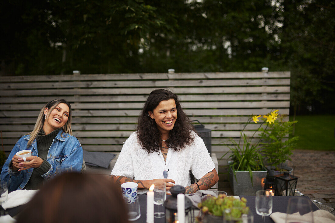 Lachende Freunde sitzen am Tisch