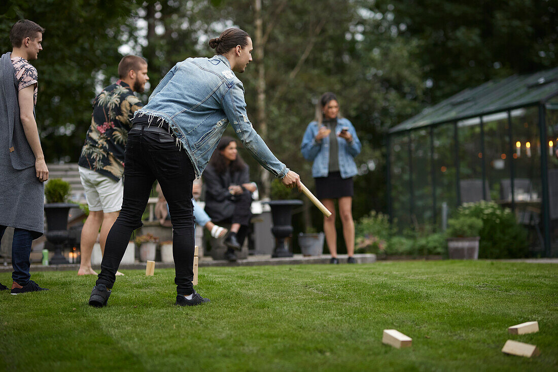 Friends playing molkky in garden