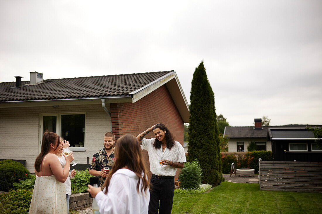 Lächelnde Freunde unterhalten sich im Garten