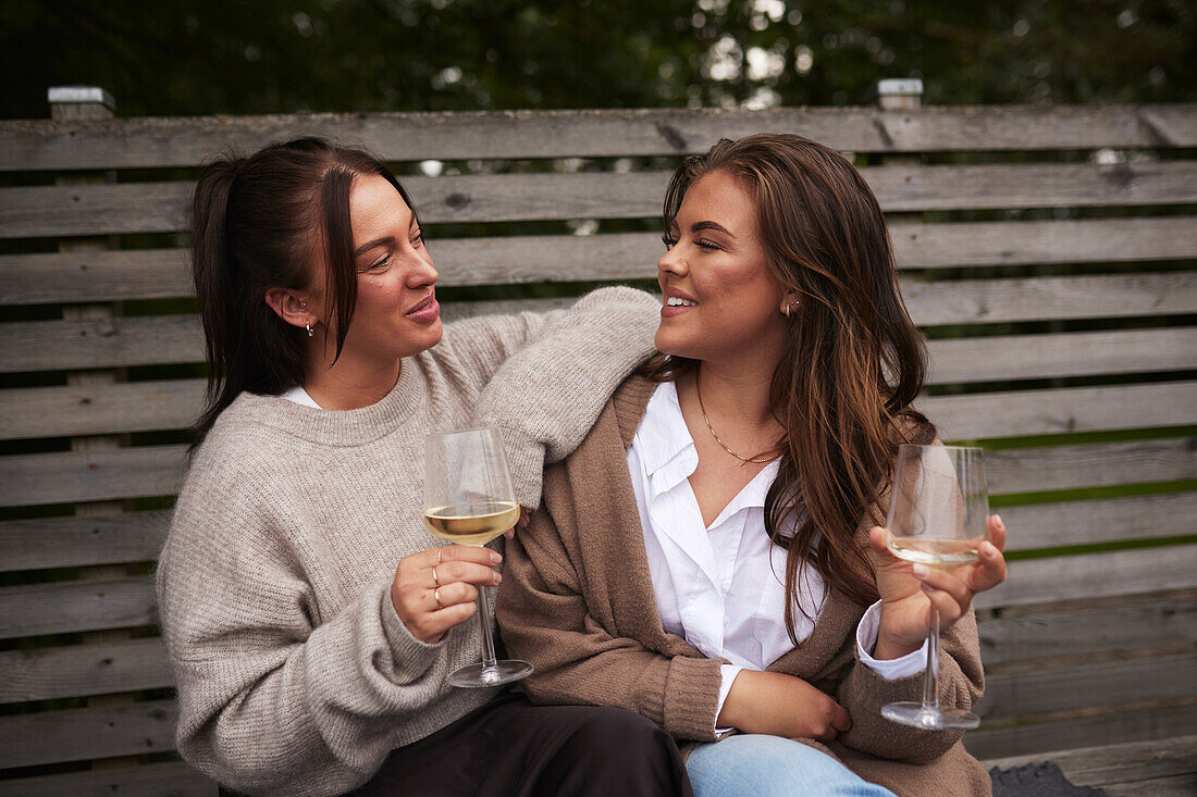 Smiling female friends relaxing in garden