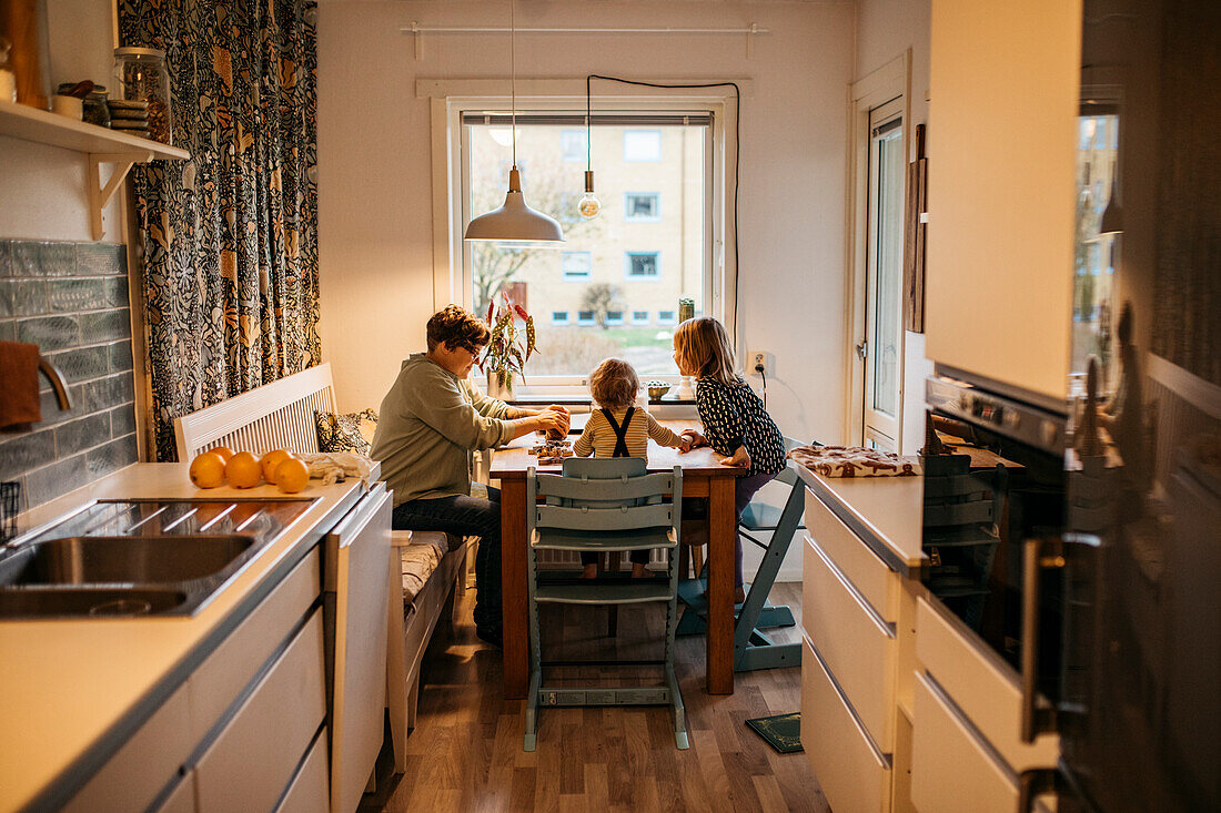 Mother and children sitting at kitchen table