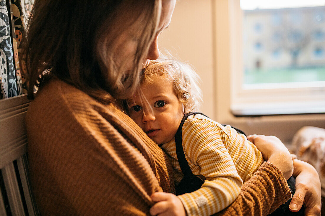 Mother hugging son at home