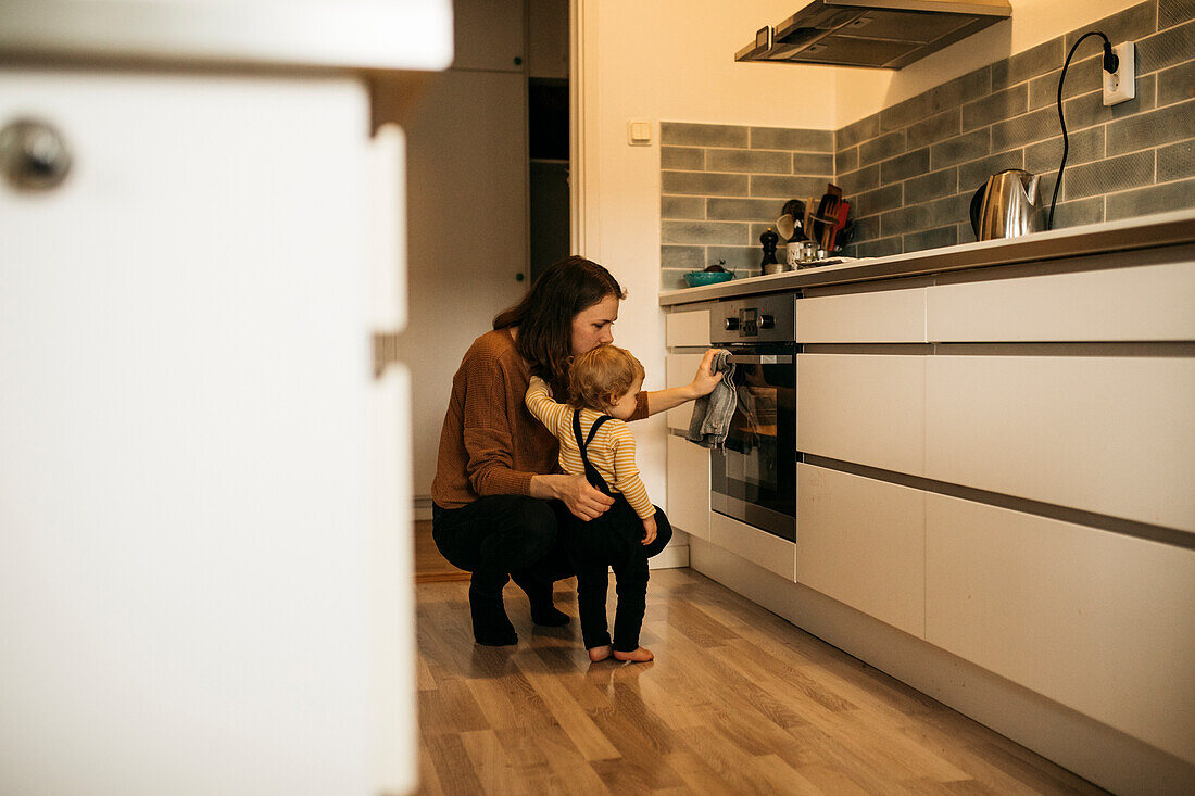 Mother and son checking kitchen oven